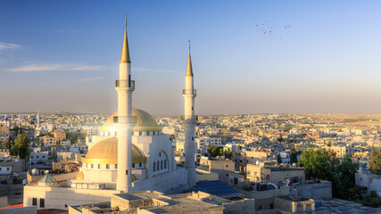 Captivating cityscape of Madaba showcasing a majestic King Hussain Mosque against a serene sky,...
