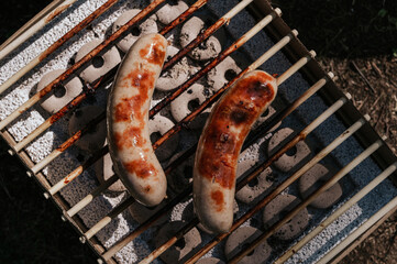 Top view on sausages on eco grill. Outdoor picnic