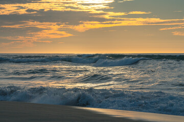 Sunset beach. Stormy sea waves and beautiful cloudy sky