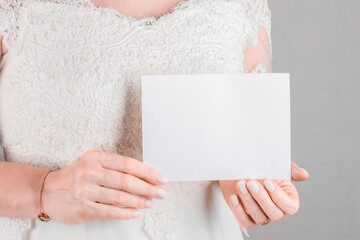 Bride holding wedding stagionery invitation card mockup 7x5 on white wall background. Minimal stile blank mockup, thank you card, greeting card, wedding template