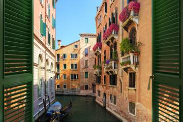 Window overlooking with picturesque view on beautiful Venetian canal. The most famous tourist destination in Italy.