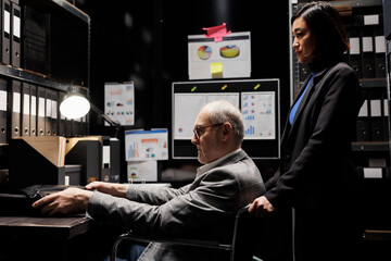 Elderly management executive businessman with paraplegia in wheelchair and asian assistant employee...