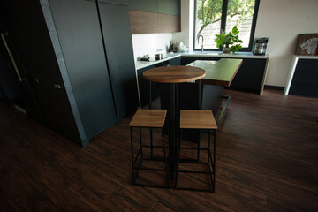 Shabby wooden table with chairs and vase located near comfortable couch against light walls with decorations in modern apartment. High quality photo