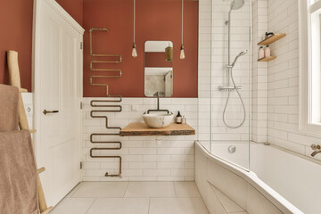 a modern bathroom with red walls and white tile flooring, including a wooden bench in the bathtub is next to the tub