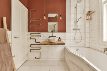 a modern bathroom with red walls and white tile flooring, including a wooden bench in the bathtub...