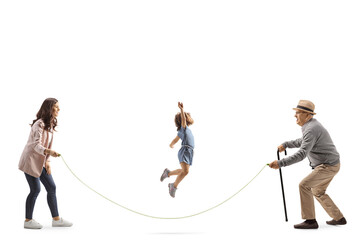 Mother, daughter and grandfather playing skipping rope