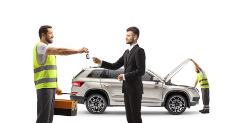 Mechanic worker returning car keys to a businessman