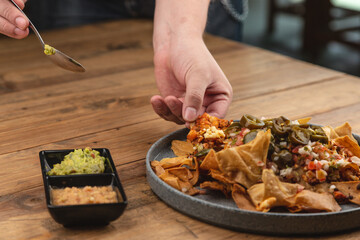 Mexican-style nachos with guacamole, pico de gallo salsa, dip, jalapeño, and cheese.




