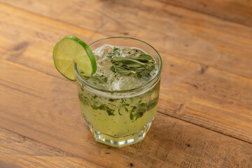 Mojito with mint, lime, and tequila on a wooden table in a restaurant.





