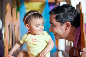 Beautiful ten months baby girl playing with her dad. Early stimulation for toddlers concept.