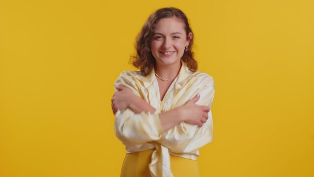 Come to me, I want to embrace you. Young woman spread hands and give hug to you. Pleasant expression, love feelings, proud, satisfied. Girl isolated alone on yellow studio background. Lifestyles