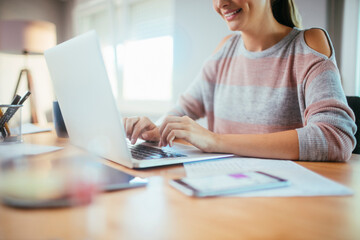 Young woman working from home on her laptop