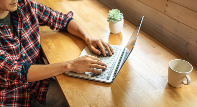 Professional man working from home with laptop, coffee cup, and wireless technology.