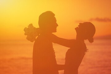 Bride and groom laughing and playing in the sunset 