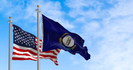 Flags of Kentucky and the United States waving in the wind on a clear day