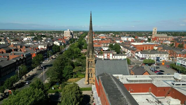 Southport, Lancashire, UK, June 24, 2023; Mid-level aerial orbital clip video footage of St George's URC Church with tall spire on Lord Street in Southport, England