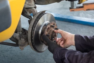 Remove the old disc brakes to replace them with new ones. © sritakoset