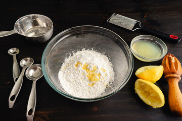 Mixing Bowl Filled with Sweet Lemon Glaze Ingredients: Glass mixing bowl with lemon glaze ingredients and kitchen tools