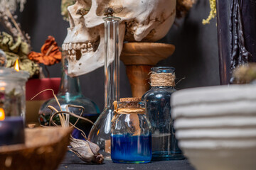 Magic liquid spell potion in the glass vials with black witchcraft candles. Mysterious witch fairy scene. Witch craft ritual background. Halloween holiday still life mystic background esoteric objects