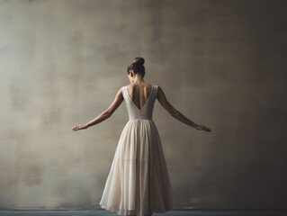 Fototapeta premium Beautiful ballerina standing near wall, back view.