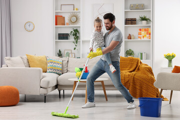Spring cleaning. Father and daughter having fun while tidying up together at home