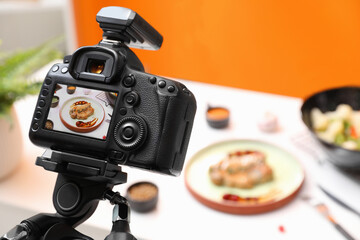 Professional camera with picture of meat medallion on display in photo studio, space for text. Food stylist