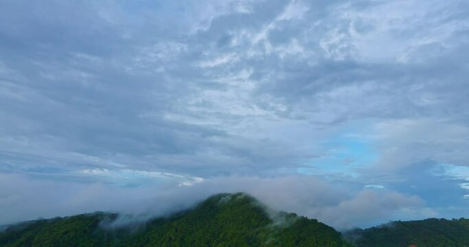 aerial view fog floating on the top of Karon mountain Phuket..white cloud in blue sky above the green mountain..white cloud in blue sky background. cloudscape background..rainy season in Phuket
