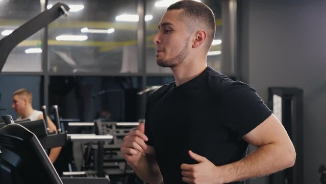 Gym Running, Treadmill Workout, Athletic Workout. Gym is where young man pursues his sports interests, including treadmill running.