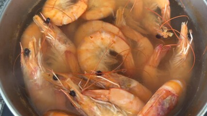 Cooking shrimp on stove in kitchen. Shrimp boiled in a pot on fire. Prepared shrimp in restaurant.  Orange red tiger prawns. Sea food prawn background. Mediterranean food. Seafood tiger shrimp
