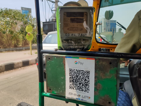 BENGALURU, KARNATAKA, INDIA, FEBRUARY 28, 2022: A Auto in India installed a google pay UPI application for a cashless payment facility. Digital India Initiative.Cashless economy concept.