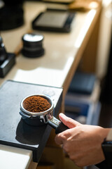 Fototapeta na wymiar Coffee grinder with ground coffee in coffee shop