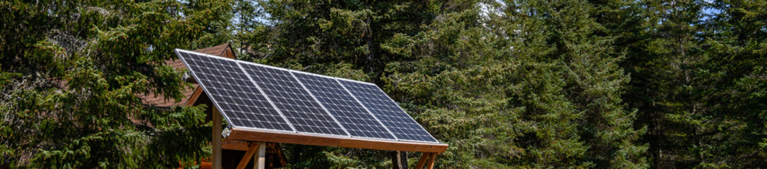Remote ecotourism camp in the forest powered by an array of solar panels, clean energy
