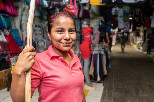 Retailer in front of a stretch of clothing with a wooden stick to place garments at a traditional market in Nicaragua