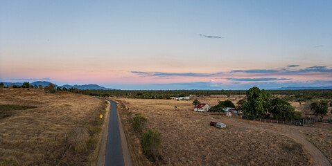 Road across cattle grazing farmland near Rockhampton, Queensland, Australia