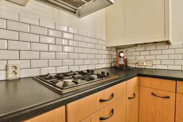 a kitchen with black counter tops and white subway tiles on the wall behind it is an oven, toaster and dishwasher