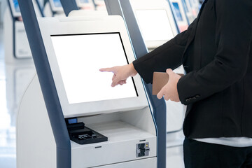 Well-dressed Businessman passenger using self service machine and help desk kiosk at airport...