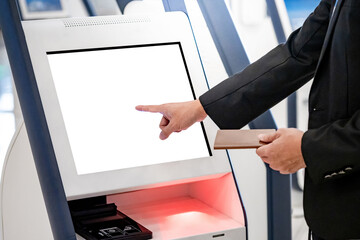 Well-dressed Businessman passenger using self service machine and help desk kiosk at airport...