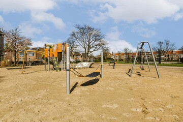 an empty playground with swings and slides in the middle part of the photo is taken from the ground...