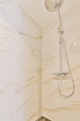 a bathroom with marble walls and white tiles on the floor, along with a shower head mounted to the wall