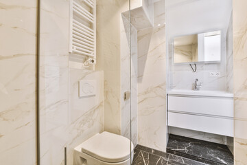 a modern bathroom with marble flooring and white walls, along with a toilet in the shower stall is next to the sink