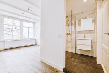 a bathroom with wood flooring and white walls in an empty room next to a large window that looks out onto the street