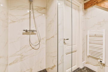 a bathroom with marble flooring and walls, including a glass shower door that has been installed in...