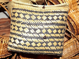 Decorated basket, with a bicolor geometric pattern made with vegetable fiber, according to the...