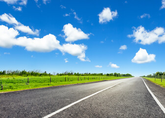 Fototapeta premium abstract empty road in summer, blue sky, white clouds, highway or speedway in rural countryside created with generative ai technology