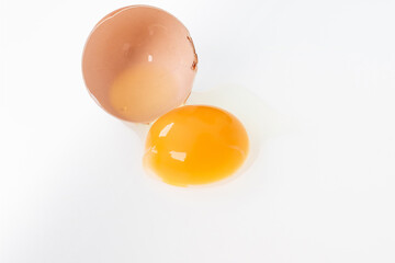 Yolk in an eggshell on a white background.