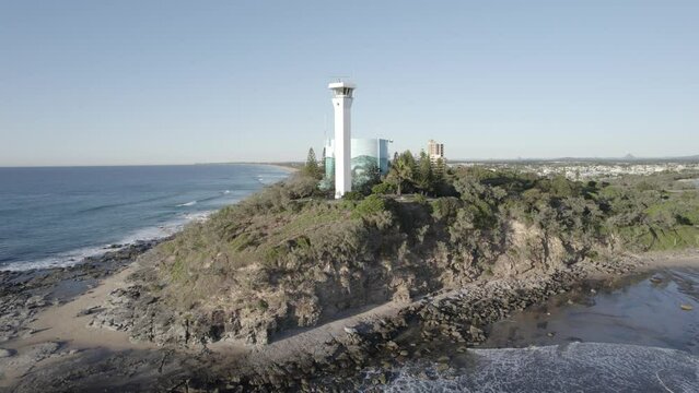 Lighthouse On Rocky Headland Of Point Cartwright In Sunshine Coast, QLD, Australia. - aerial pullback