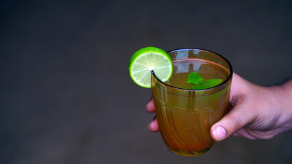 Lemonade with mint on a dark background. Healthy drinks. Side view, copy space.