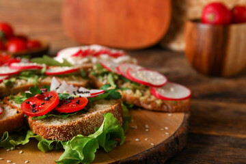 Board with delicious radish bruschettas on wooden table