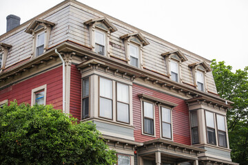 suburban house engulfed in a rising dollar sign symbolizes the meaning and symbolism of mortgage-driven inflation and the financial pressures of homeownership