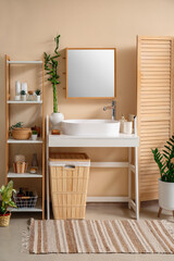 Interior of bathroom with sink, shelving unit and basket
